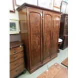 A Victorian mahogany triple wardrobe, the arch panel doors enclosing slides and drawers on plinth