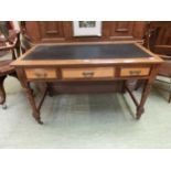 A late 19th century walnut writing table, the top over three sycamore veneered drawers on turned