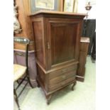 An early 20th century walnut music cabinet, the paneled door over three drawers on cabriole legs