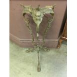 A cast brass and pierced stand, three legs with masked finials and paw feet