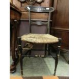 A 19th century ebonized parcel gilt and floral framed single chair with rush seat (A/F)