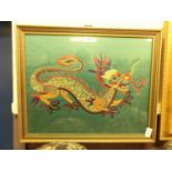 A framed and glazed needlework of a dragon