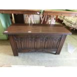 An early 20th century oak ottoman with linen fold design to front