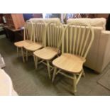 A set of four yellow painted spindle back dining chairs