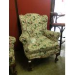 An early 20th century high back wing arm chair having cabriole supports on ball on claw feet