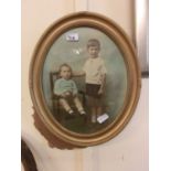 An oval gilt framed picture of young children