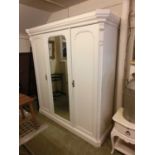 A cream painted Victorian mahogany compactum having a glazed center door being flanked by cupboard