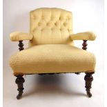 An early 20th century walnut arm chair upholstered in a button back white gold fabric on turned