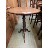 An early 19th century oak tilt top table, the moulded top over a turned column and three legs, h. 70