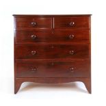 An early 19th century mahogany chest of two short over three long drawers over shaped apron, h.