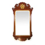 A Georgian mahogany and parcel gilt fretwork mirror, the beveled plate surrounded by the moulded