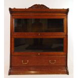 An early 20th century oak sectional bookcase, the top section with carved gallery over two glazed