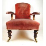 A 19th century mahogany open arm chair upholstered in a pink button back fabric, on turned front