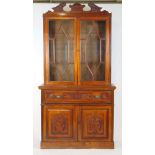 An Edwardian walnut secretaire bookcase, the swan neck pediment over two astragal glazed doors above