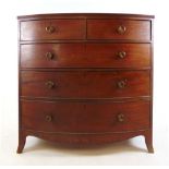 An early 19th century mahogany bow front chest of two short over three long drawers on splay feet,