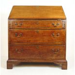 An 18th century oak bureau, the fall front revealing a fitted interior over three long drawers on