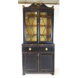 A Regency secretaire bookcase. The pediment over two glazed doors on the base with secretaire drawer