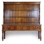 An 18th century style oak dresser, the plate rack over the base with three drawers on turned legs,