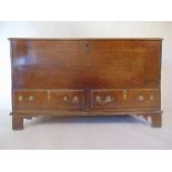 An 18th century oak mule chest, the top lifting to reveal a vacant interior with candle box over two