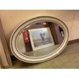 A white and grey painted framed oval bevel glass mirror