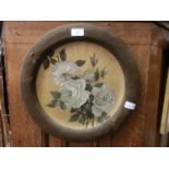 A framed ceramic plate with painted rose design