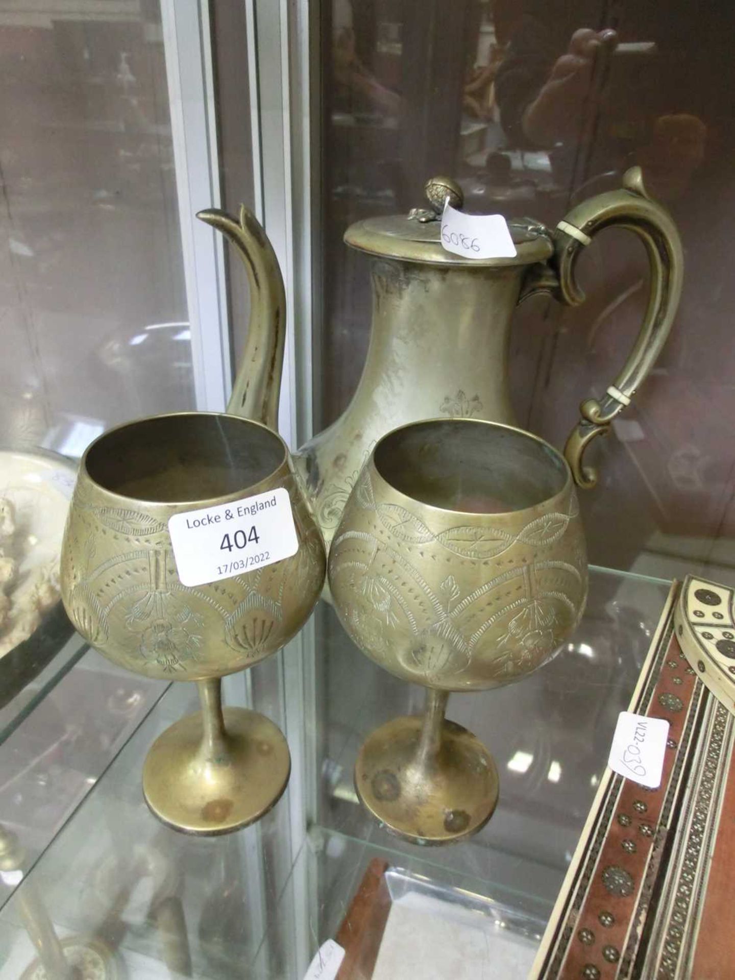 A metalwork teapot together with two etched drinking vessels