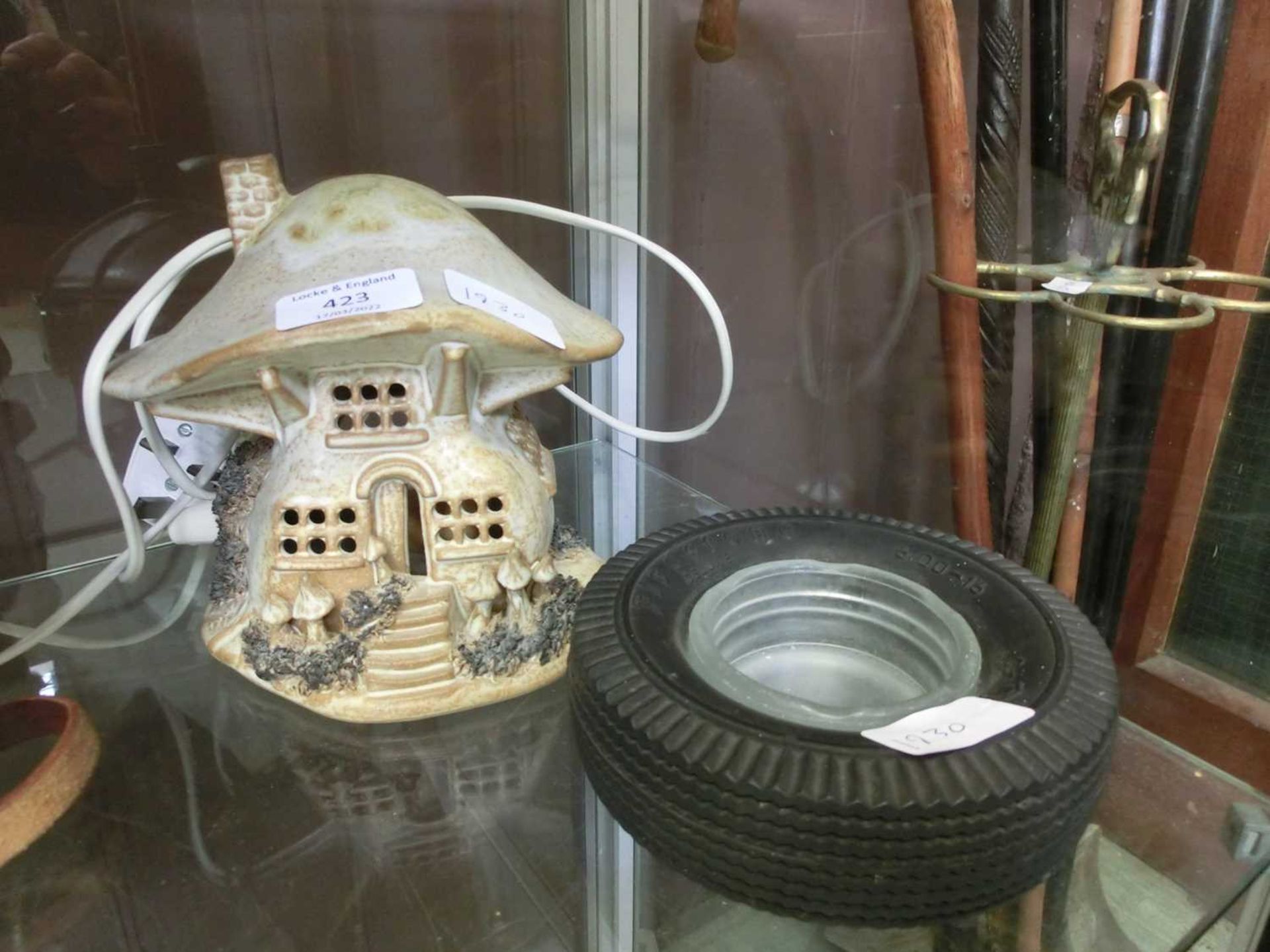 A firestone tyre in the form of an ashtray together with a ceramic lamp in the form of a cottage