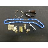 A bag containing an assortment of costume jewellery to include blue beads, yellow metal items, etc