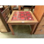 A mid-20th century teak occasional table with a red tiled top