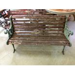 A weathered wooden garden bench with metal ends