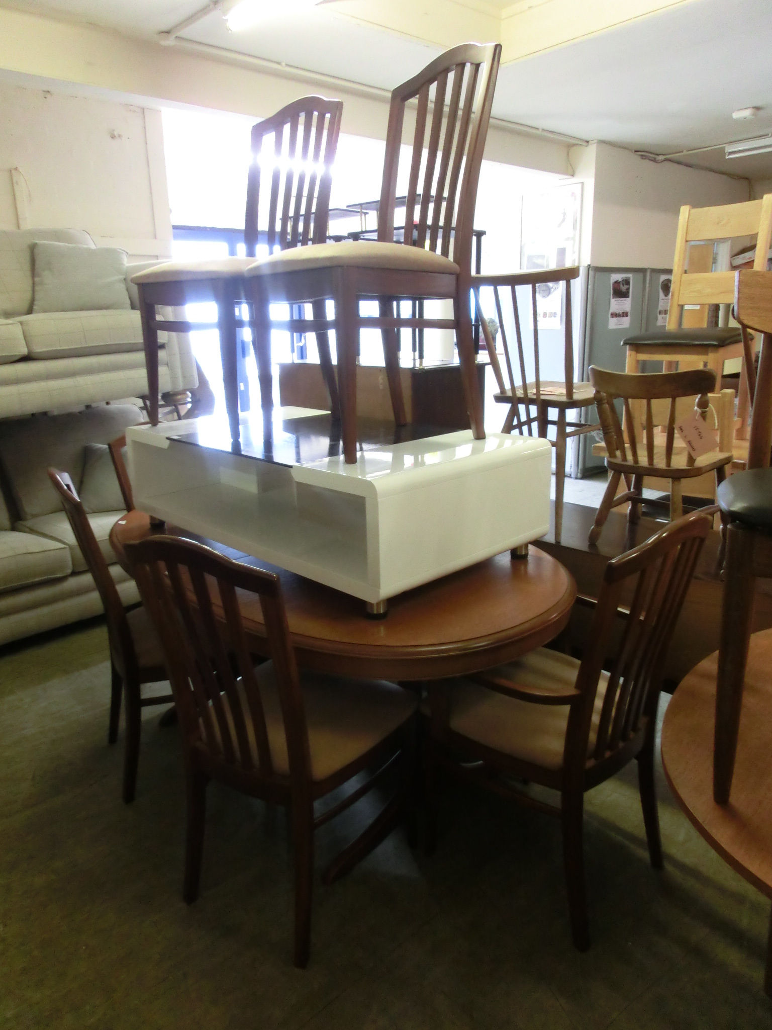 A modern teak oval extending dining table together with a set of four standard and two carver