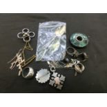 A bag containing an assortment of costume jewellery, teaspoon, brooches, etc