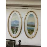 A pair of oval framed and glazed watercolours of mountain scenes