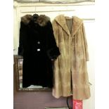 A light brown fur coat together with a black full length fur coat
