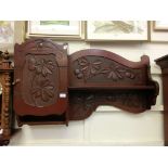 A carved mahogany wall mounted cupboard with shelf