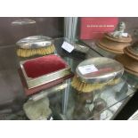 Four silver items to include brushes, trinket box, pin cushion, etc