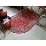 A red ground oval rug