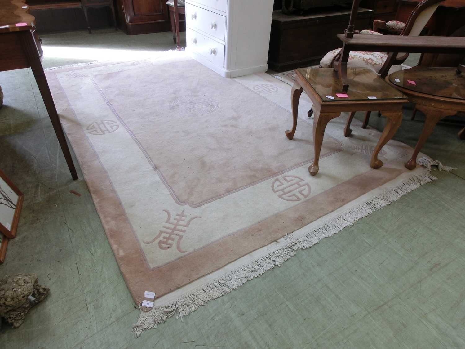 A Chinese style beige and cream ground rug