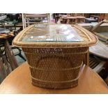 A wicker occasional table with glass panel to top