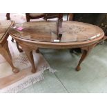 An eastern hardwood brass inlaid oval table with cabriolet supports