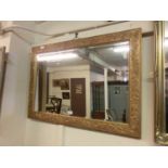 A floral gilt framed bevel glass mirrorDimensions: Without frame: 49 x 75cmWith frame: 62 x 88cm