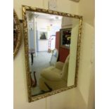 A floral gilt framed bevel glass mirror