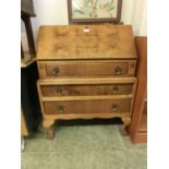 An early 20th century walnut bureau, the fall front over three long drawers on cabriole legs