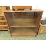 A mid-20th century teak bookcase with glazed sliding doors