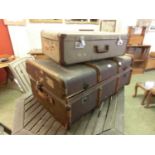 An early 20th century oil, skin, and wooden bound travelling trunk along with suitcase