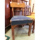 An Arts and Crafts style oak chair with a distressed blue leather upholstered seat