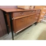 A mid-20th century teak sideboard having two drawers above cupboard doors