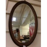 An Edwardian walnut oval bevel glass mirror