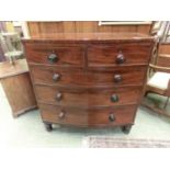 An early 19th century mahogany bow front chest of two short over three long drawers on turned legs