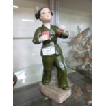 A Chinese ceramic figure of revolutionary girl in uniform